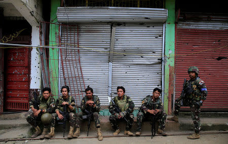 Government soldiers takes a break in front of a damaged building in Sultan Omar Dianalan boulevard at Mapandi district in Marawi city, southern Philippines September 13, 2017. Picture taken September 13, 2017. REUTERS/Romeo Ranoco