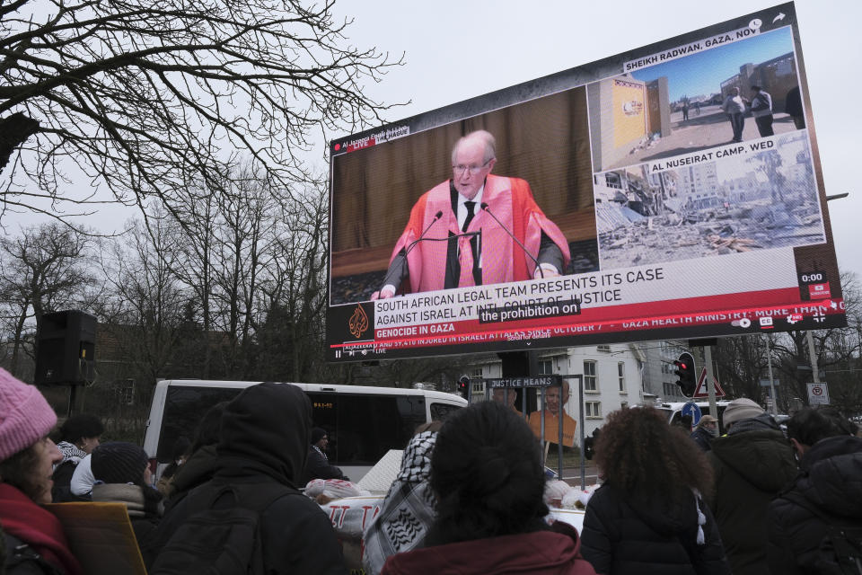 Protestors watch South African legal adviser John Dugard on a large video screen, as they follow the hearings during a demonstration march outside the International Court of Justice in The Hague, Netherlands, Thursday, Jan. 11, 2024. The United Nations' top court opens hearings Thursday into South Africa's allegation that Israel's war with Hamas amounts to genocide against Palestinians, a claim that Israel strongly denies. (AP Photo/Patrick Post)