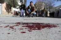 An Afghan journalist films the site where gunmen fired in Kabul, Afghanistan, Sunday, Jan. 17, 2021. Gunmen fired on a car in northern Kabul on Sunday, killing two women judges who worked for Afghanistan's high court and wounding the driver, a court official said. It was the latest attack in the Afghan capital during peace talks between Taliban and Afghan government officials in Qatar. (AP Photo/Rahmat Gul)