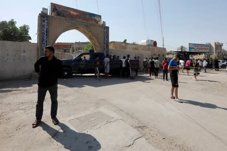People gather at the site of a bomb attack at a Shi'ite Muslim mosque in the Baladiyat neighbourhood of Baghdad