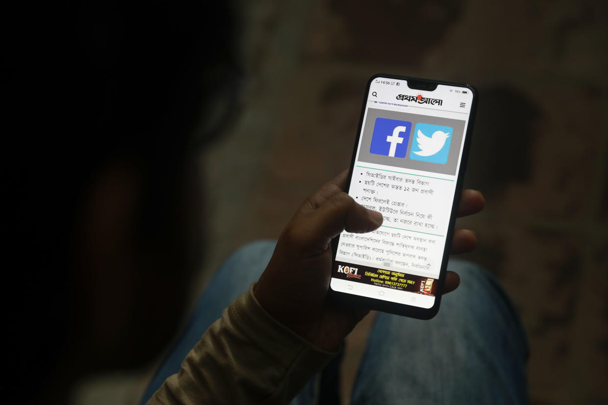 File Photo: A Bangladeshi reads a news report that makes mention of Facebook along with other social networking service, on his mobile phone in Dhaka, Bangladesh, Thursday, Dec. 20, 2018. (AP Photo)