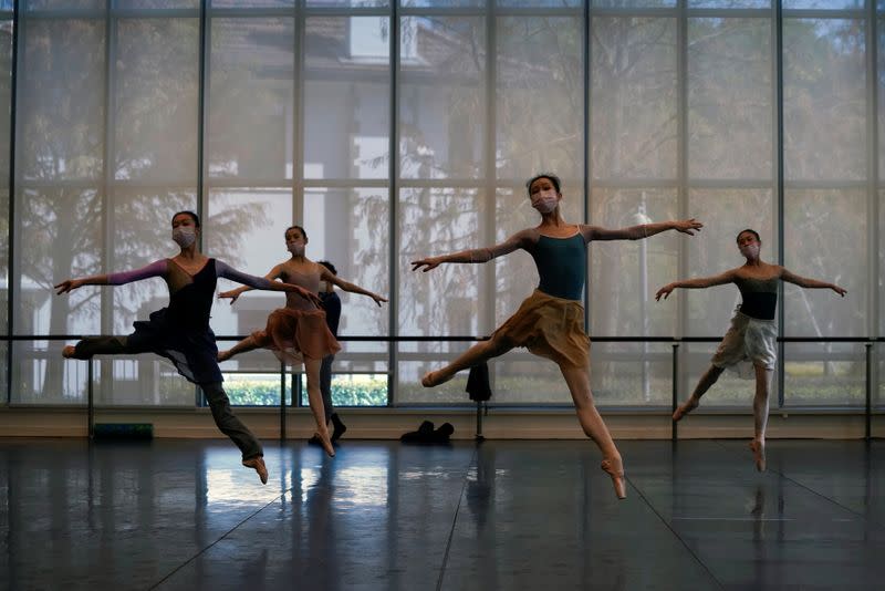 Bailarines de ballet con máscaras practican en un estudio de baile en Shanghái