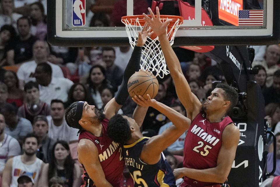 New Orleans Pelicans guard Trey Murphy III (25) goes up for a shot against Miami Heat center Orlando Robinson (25) and guard Gabe Vincent, left, during the first half of an NBA basketball game, Sunday, Jan. 22, 2023, in Miami. (AP Photo/Wilfredo Lee)