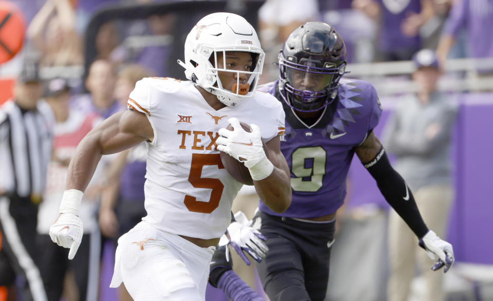 Texas running back Bijan Robinson (5) runs for a touchdown as TCU cornerback C.J. Ceasar II (9) pursues during the first half of an NCAA college football game Saturday, Oct. 2, 2021, in Fort Worth, Texas. (AP Photo/Ron Jenkins)