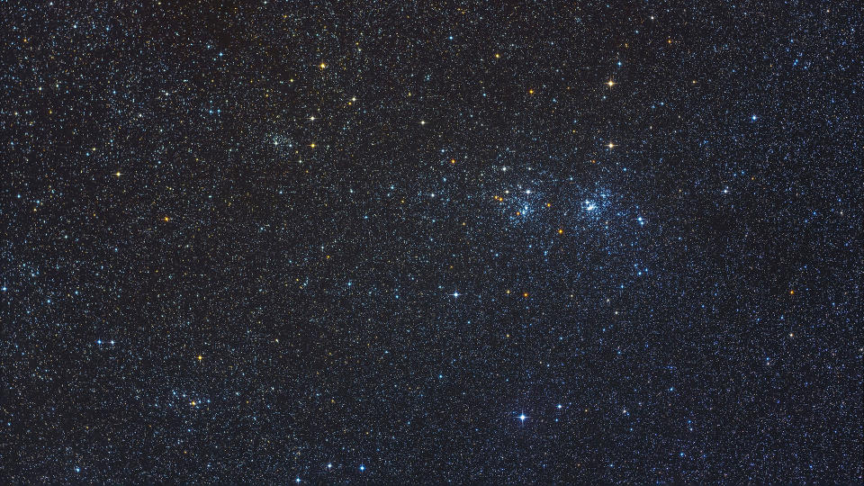 The well-known Double Cluster (aka NGC 884 and NGC 869) framed at upper right to include two of its companion star clusters, NGC 957 at upper left and Trumpler 2 at lower left. Dotted through the field of young blue stars are numerous aging yellow giant stars. And the gradation in sky colour from the clearer, bluer sky with more stars at right to the dustier, yellower sky and fewer stars at left is subtle but obvious here, from interstellar dust in this part of the Milky Way. . (Photo by: Alan Dyer/VW Pics/Universal Images Group via Getty Images)