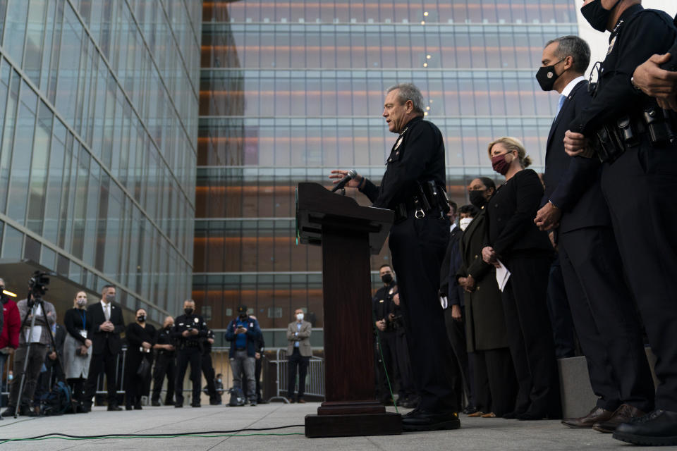 FILE - Los Angeles Police Chief Michel Moore, center, speaks during a news conference as he is joined by Mayor Eric Garcetti, second from right, outside the Los Angeles Police Headquarters Thursday, Dec. 2, 2021, in Los Angeles. Moore announced his retirement Friday, Jan. 12, 2024, in an unexpected departure as the head of one of the nation's largest law enforcement agencies. (AP Photo/Jae C. Hong, File)