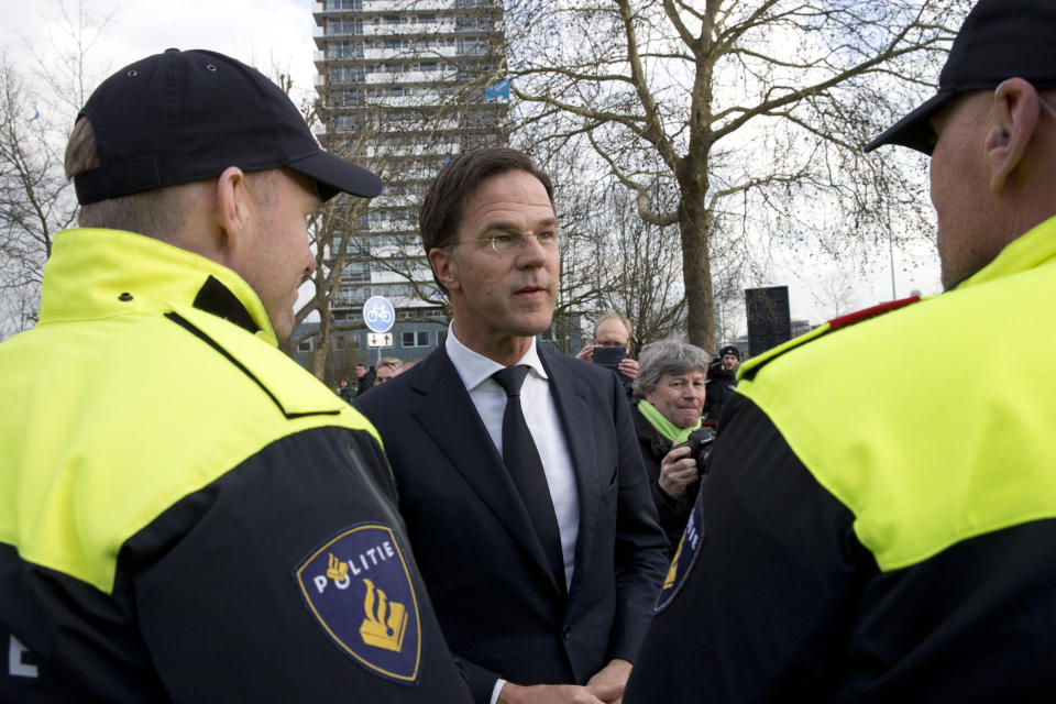Dutch Prime Minister Mark Rutte expresses his gratitude to Dutch police officers after laying flowers at a makeshift memorial for victims of a shooting incident in a tram in Utrecht, Netherlands, Tuesday, March 19, 2019. A gunman killed three people and wounded others on a tram in the central Dutch city of Utrecht Monday March 18, 2019. (AP Photo/Peter Dejong)
