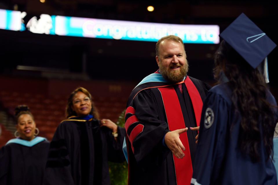 Principal Dr. Shannon Gibson shakes a studentÕs hand as he hands her a diploma during the J.L. Mann Class of 2024 commencement ceremony at Bon Secours Wellness Arena on Wednesday, May 22, 2024.