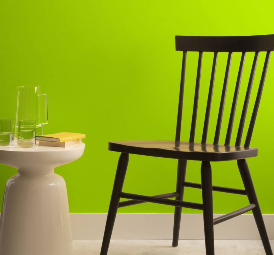 Chair and side table in front of a wall painted in Lime Green by Benjamin Moore.