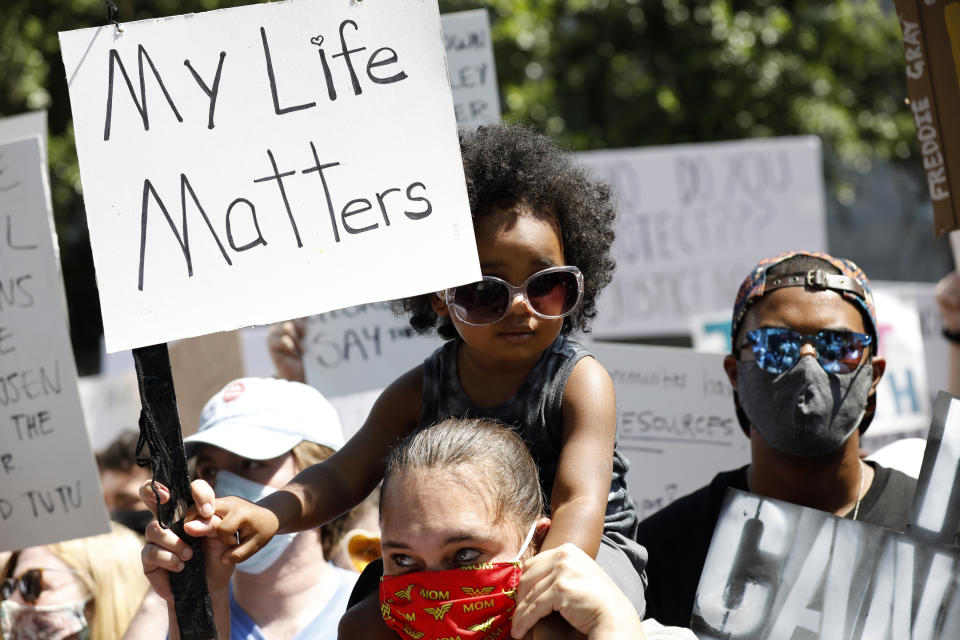 Alex Smith, 3, sits on his mother's, Maya Teeuwissen, shoulders during a rally and march in downtown Jackson, Miss., in response to the recent death of George Floyd, and to highlight police brutality nationwide including Mississippi, Saturday, June 6, 2020. The Mississippi branch of Black Lives Matter coordinated the events to also encouraged the participants to push leaders to seek long term solutions to issues plaguing the African American community. (AP Photo/Rogelio V. Solis)