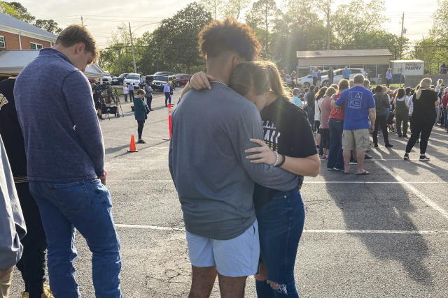 Two teens embrace at a prayer vigil on Sunday, April 16, 2023, outside First Baptist Church in Dadeville, Ala. Several people were killed and over two dozen were injured in a shooting at a teen birthday party in the town on Saturday, April 15. (AP Photo/Jeff Amy)