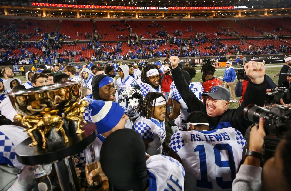 Kentucky coach Mark Stoops celebrates with his players after routing Louisville last season. MATT STONE/Louisville Courier Journal