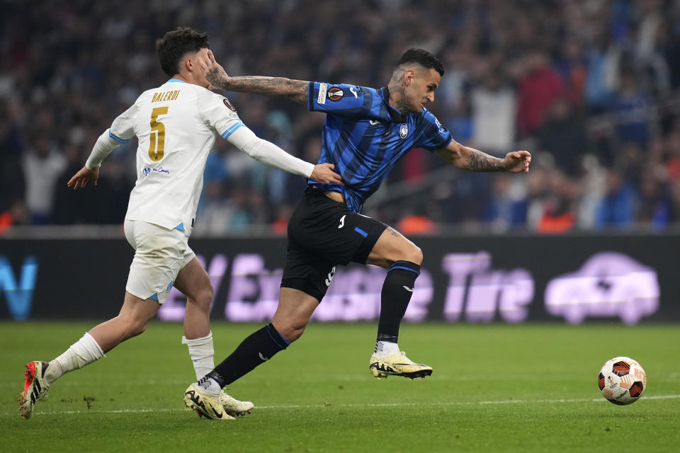 Marseille's Leonardo Balerdi, left, challenges Atalanta's Gianluca Scamacca during the Europa League semifinal first leg soccer match between Olympique de Marseille and Atalanta at the Velodrome stadium in Marseille, France, Thursday, May 2, 2024. (AP Photo/Daniel Cole)