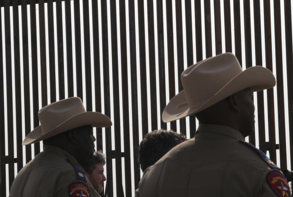 FILE - Texas Department of Safety troopers are silhouetted against the Texas Border Wall, Dec.18, 2021 in Rio Grande City, Texas. About 3 in 10 also worry that more immigration can cause native-born Americans to lose their economic, political and cultural influence, according to a poll by The Associated Press-NORC Center for Public Affairs Research. (Delcia Lopez/The Monitor via AP, File)