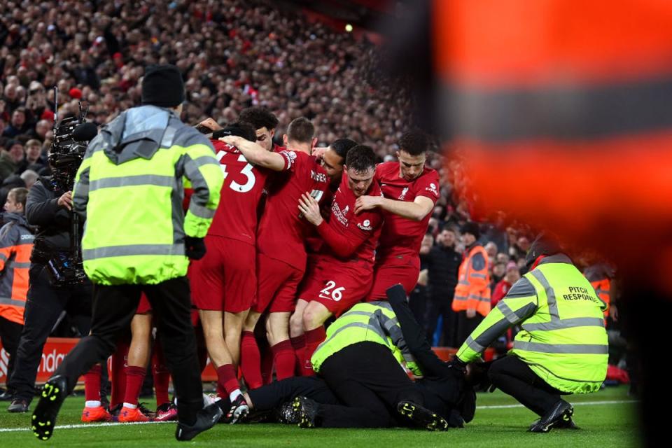 A pitch invader is tackled by stewards after colliding with Liverpool player Andy Robertson (Getty Images)