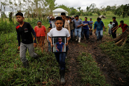 Friend and family carry a coffin with the remains of Jakelin Caal, a 7-year-old girl who handed herself in to U.S. border agents earlier this month and died after developing a high fever while in the custody of U.S. Customs and Border Protection, during her funeral at her home village of San Antonio Secortez, in Guatemala December 25, 2018. REUTERS/Carlos Barria