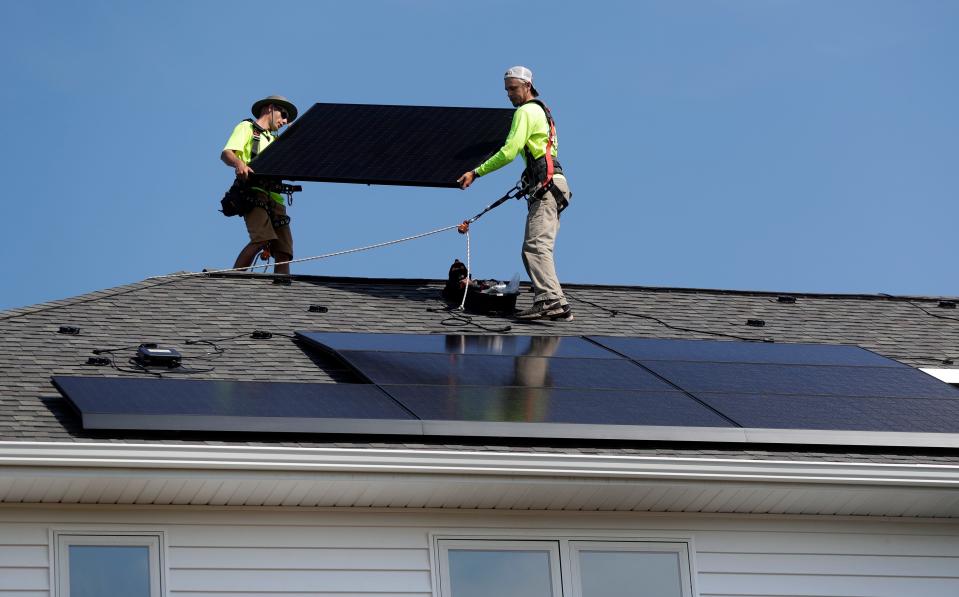 Appleton Solar crew members install solar panels on the roof of a residence on Aug. 23, 2022, in the town of Lawrence, Wis.