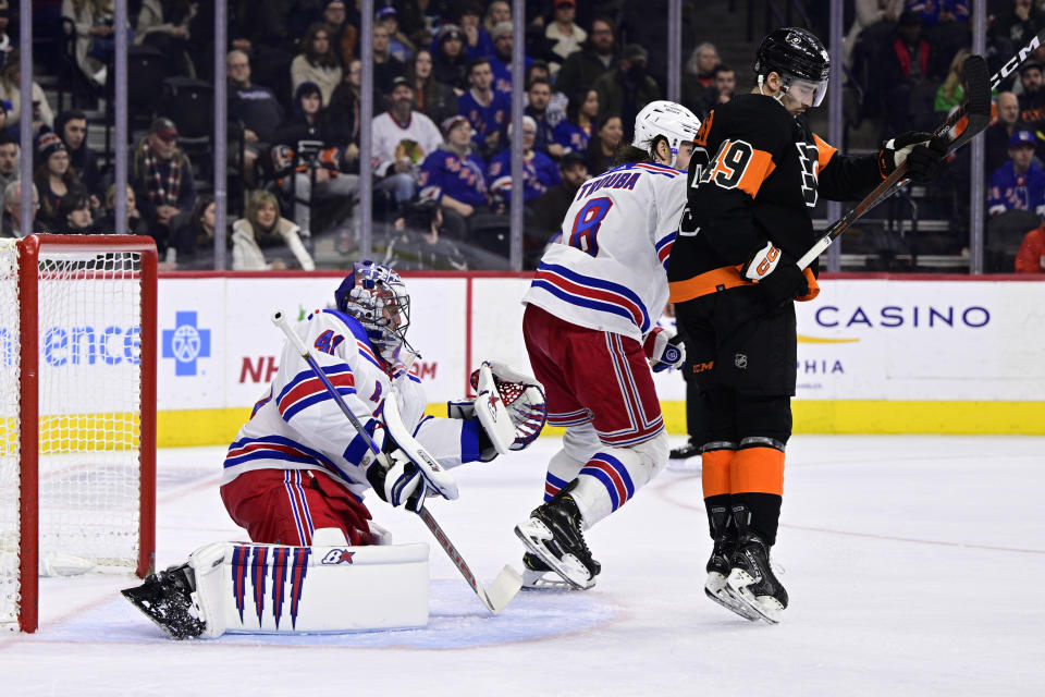 New York Rangers goaltender Jaroslav Halak makes a glove save past the defense of Jacob Trouba and Philadelphia Flyers' Noah Cates during the second period of an NHL hockey game, Saturday, Dec. 17, 2022, in Philadelphia. (AP Photo/Derik Hamilton)