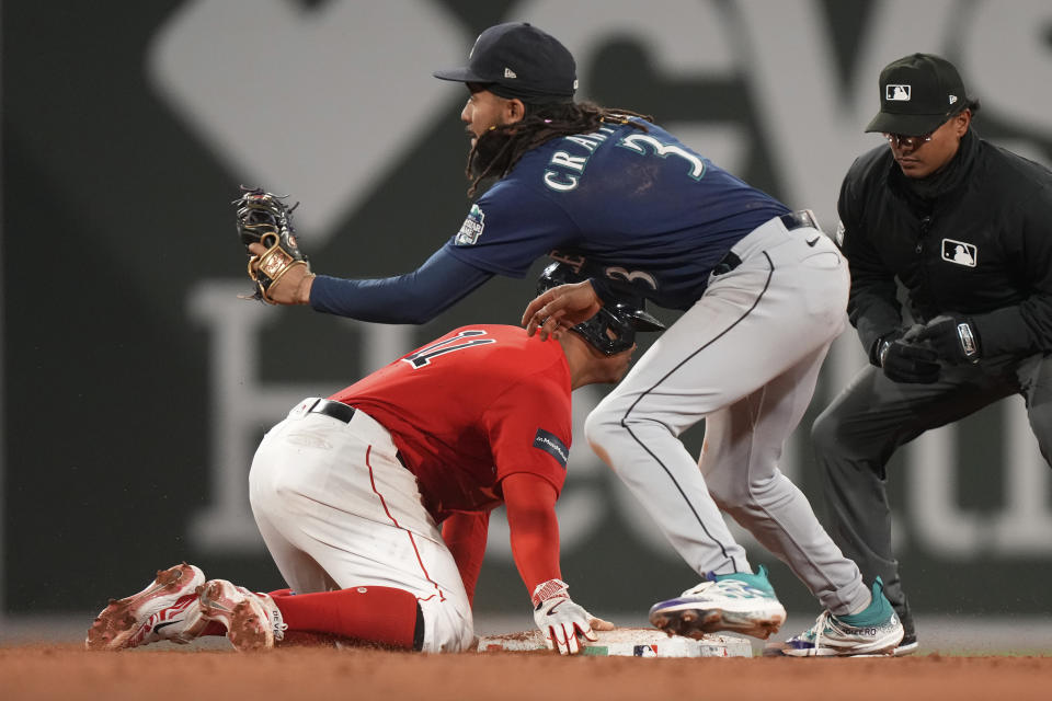 Boston Red Sox's Rafael Devers (11) is safe at second with a double as Seattle Mariners' J.P. Crawford (3) catches the throw the fifth inning of a baseball game Wednesday, May 17, 2023, in Boston. (AP Photo/Steven Senne)
