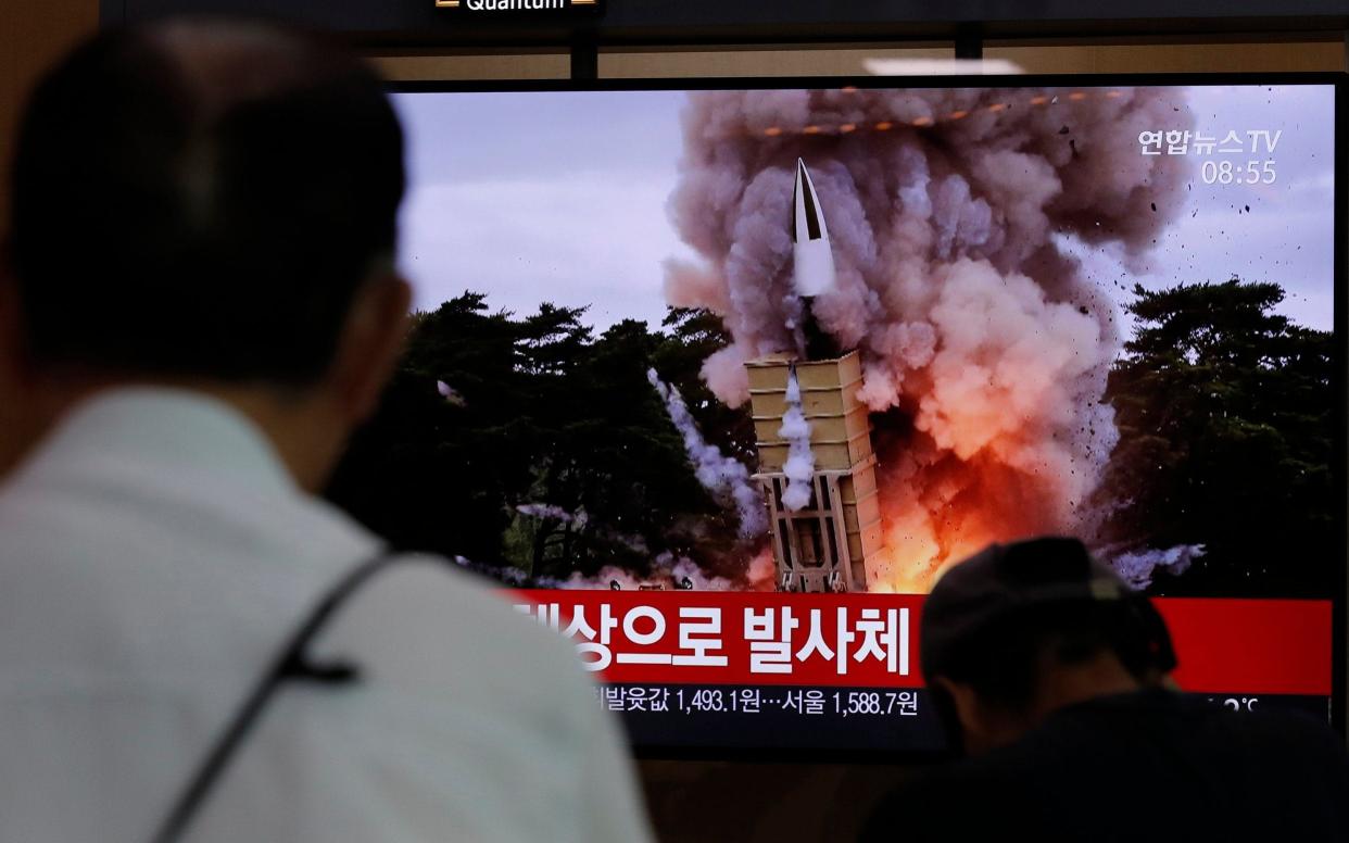 People watch a TV news programme reporting North Korea's firing projectiles at the Seoul Railway Station - AP