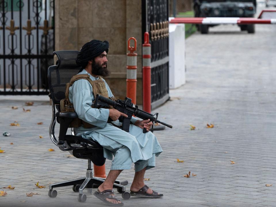 A Taliban fighter guards a gate after a gathering attended by Afghanistan's Prime Minister Mohammad Hassan Akhund and Minister for Promotion of Virtue and Prevention of Vice Sheikh Mohammad Khalid at the former presidential palace in Kabul on August 13, 2022.