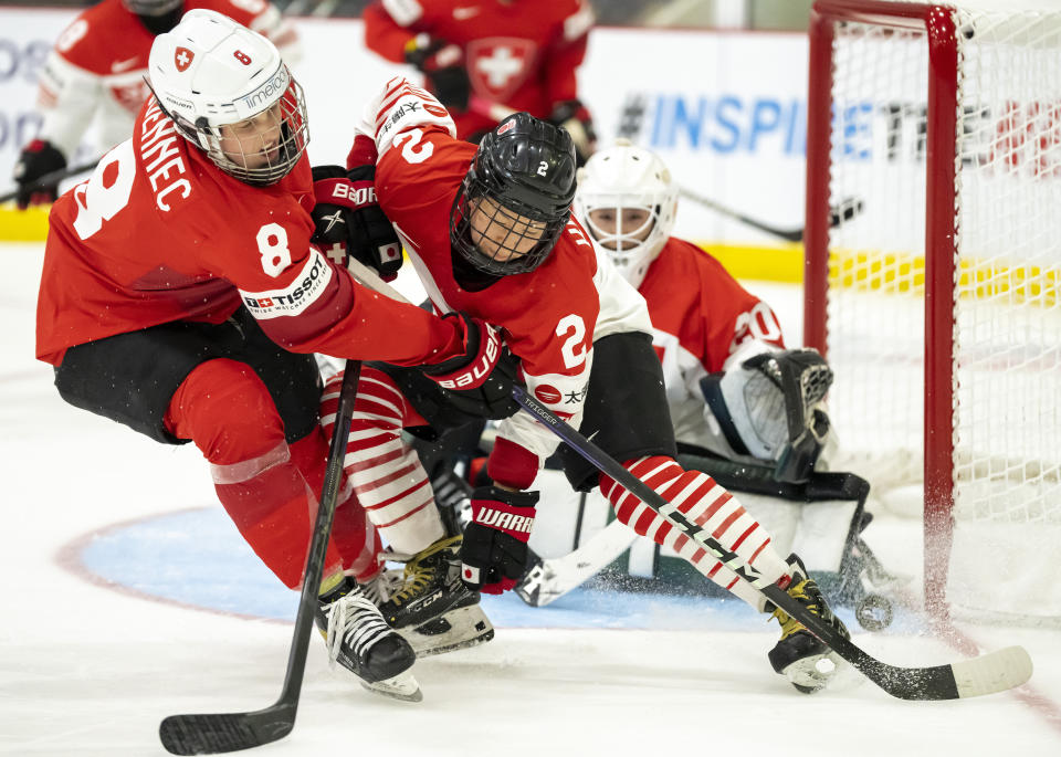 Switzerland forward Kaleigh Quennec (8) and Japan defender Shiori Koike (2) vie for the puck in front of Japan goaltender Miyuu Masuhara (20) during the first period of a women’s world hockey championships quarterfinal, Thursday, April 13, 2023, in Brampton, Ontario. (Frank Gunn/The Canadian Press via AP)