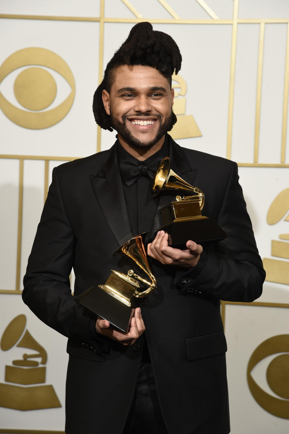 FILE - The Weeknd poses in the press room with the awards for best R&B performance for "Earned It (Fifty Shades of Grey)" and best urban contemporary album for "Beauty Behind The Madness" at the 58th annual Grammy Awards in Los Angeles on Feb. 15, 2016. The Weeknd had the No. 1 song of 2020 but “Blinding Lights” was not nominated for a Grammy Award. (Photo by Chris Pizzello/Invision/AP, File)
