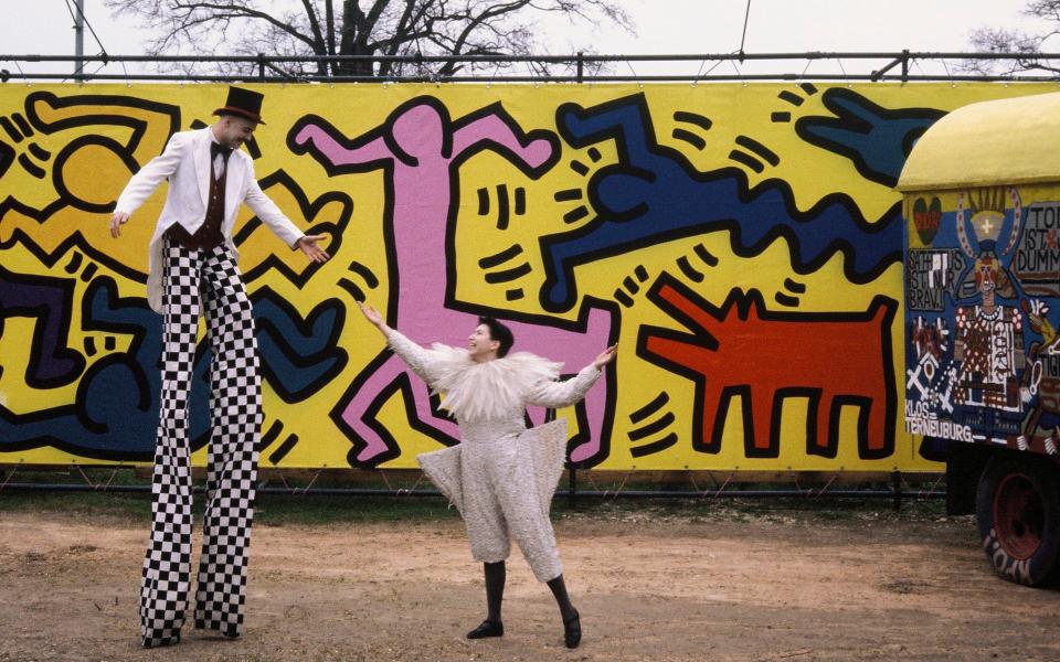 The artist Keith Haring designed posters and a carousel for Luna Luna with narrative walls leading away from it in a star formation, pictured here with roaming carnival performers