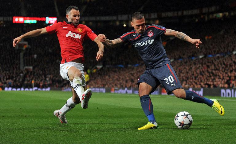 Ryan Giggs (left) closes in on Olympiakos' Greek defender Jose Holebas during the Champions League game against Olympiakos at Old Trafford on March 18, 2014