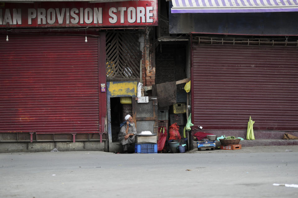 An elderly Kashmiri man sells cheese at a closed market in Srinagar, Indian controlled Kashmir, Wednesday, Aug. 28, 2019. India's government, led by the Hindu nationalist Bharatiya Janata Party, imposed a security lockdown and communications blackout in Muslim-majority Kashmir to avoid a violent reaction to the Aug. 5 decision to downgrade the region's autonomy. The restrictions have been eased slowly, with some businesses reopening, some landline phone service restored and some grade schools holding classes again, though student and teacher attendance has been sparse. (AP Photo/Mukhtar Khan)