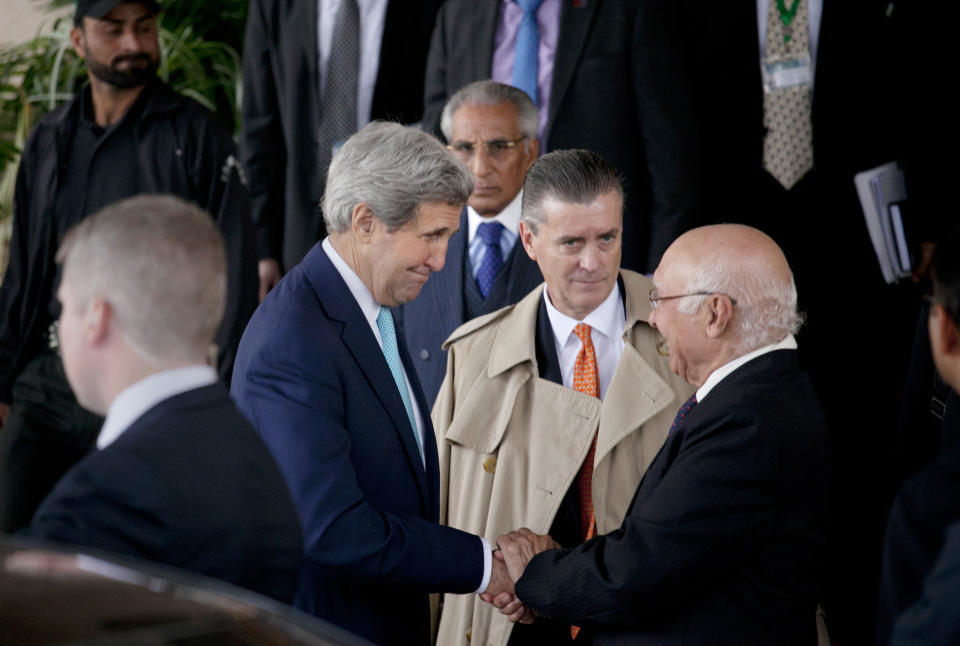 FILE - Pakistani Prime Minister's adviser on foreign affairs Sartaj Aziz, right, shakes hand with U.S. Secretary of State John Kerry, left, as U.S. Ambassador to Pakistan Richard Olson, center, watches him after their joint press conference in Islamabad, Pakistan, Jan. 13, 2015. Olson was sentenced to three years of probation and ordered to pay a $93,350 fine Friday, Sept. 15, 2023, for improperly helping a wealthy Persian Gulf country influence U.S. policy and not disclosing gifts he received from a disgraced political fundraiser. (AP Photo/Anjum Naveed, File)