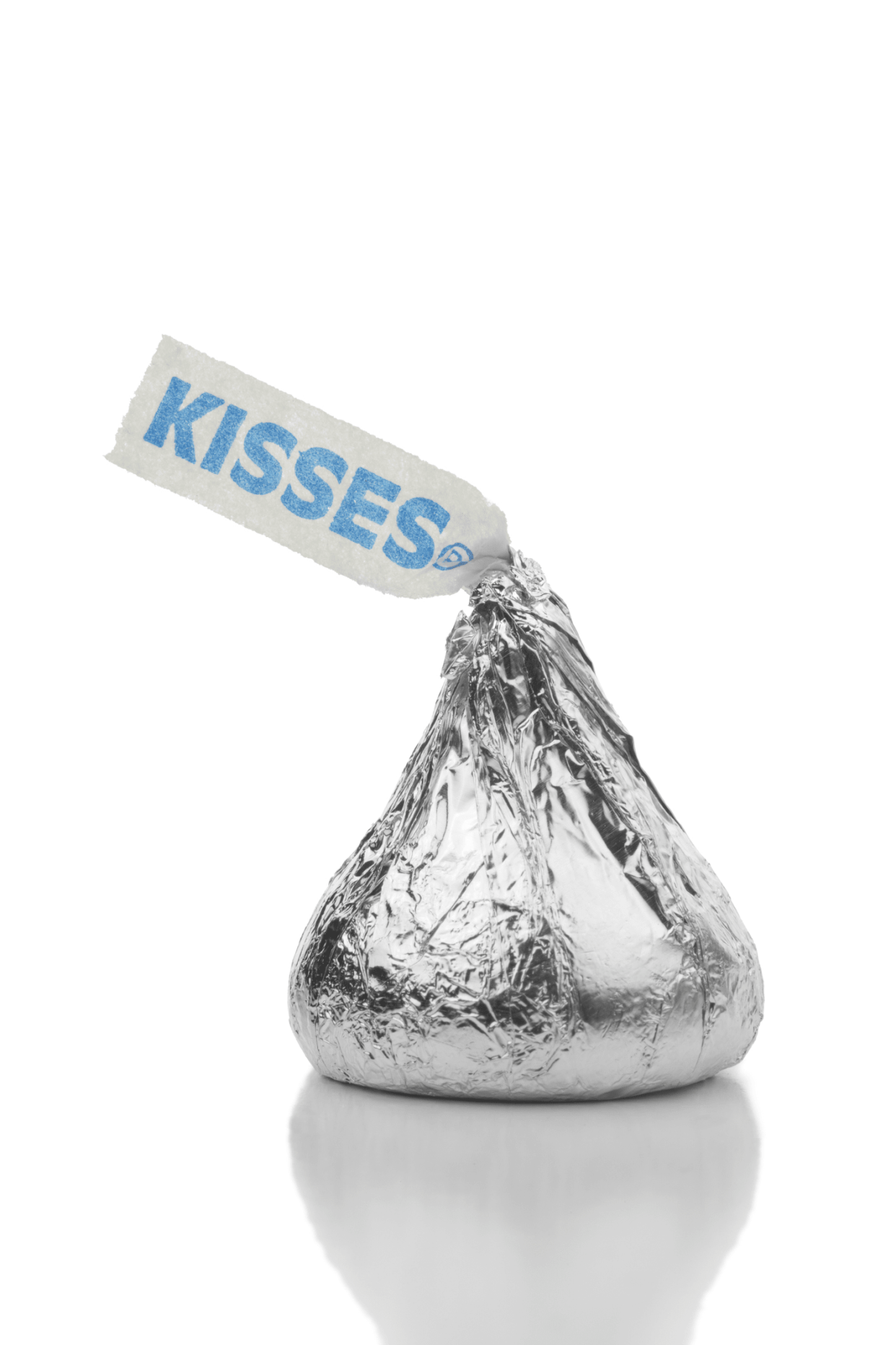 One Hershey's Kiss wrapped in silver foil, little top flag is pointed to the left, with a shadow on a clear white background