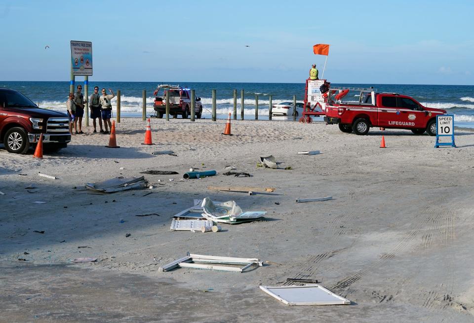 Debris from a toll booth destroyed by an out-of-control car is scattered along the International Speedway Boulevard beach approach in Daytona Beach on Sunday.