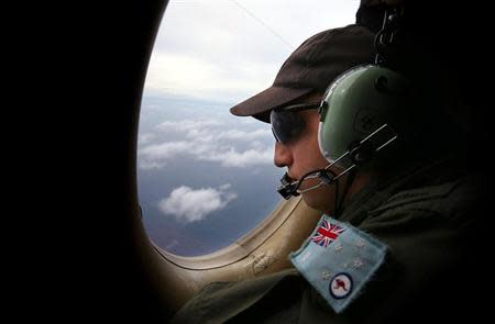 Airbourne Electronics Analyst Ben Herbert looks out an observation window from a Royal Australian Air Force (RAAF) AP-3C Orion aircraft while searching for the missing Malaysia Airlines Flight MH370 over the southern Indian Ocean March 26, 2014. REUTERS/Paul Kane/Pool