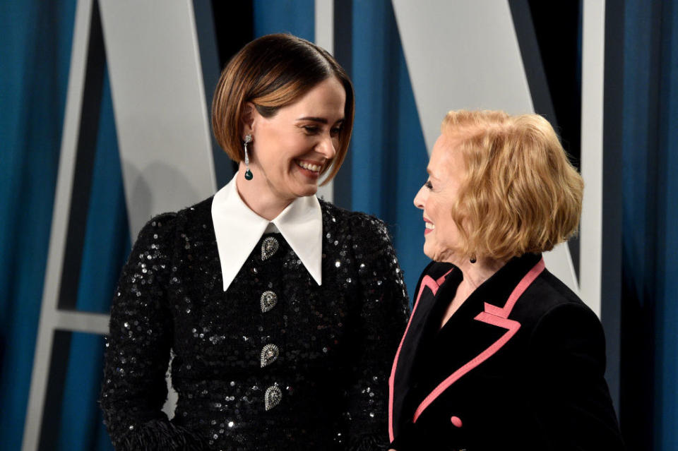 Sarah and Holland smiling at each other on a red carpet