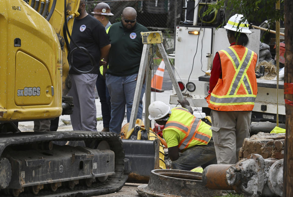 Workers fix a water main break at Joseph E. Boone Boulevard and James P. Brawley Drive, Saturday, June 1, 2024, in Atlanta. City officials were slowly repressuring the city's water system Saturday after corroding water pipes burst in downtown and Midtown, forcing many businesses and attractions to close and affecting water service in area homes. (Hyosub Shin/Atlanta Journal-Constitution via AP)
