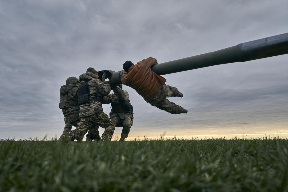 FILE - Ukrainian soldiers prepare a U.S.-supplied M777 howitzer to fire at Russian positions in Kherson region, Ukraine, Jan. 9, 2023. A rapidly expanding group of U.S. and allied troops and contractors are using phones and tablets to communicate in encrypted chat rooms to provide real-time maintenance advice to Ukrainian troops on the battlefield. As the U.S. and other allies provide a growing number of increasingly complex and high-tech weapons, the maintenance demands are expanding. (AP Photo/Libkos, File)