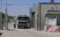 FILE - A Hamas security officer checks a truck entering Gaza at the gate of the Kerem Shalom cargo crossing with Israel, in Rafah, southern Gaza Strip, on June 21, 2021. Israel will reopen the main commercial crossing to Gaza Sunday Sept. 10, 2023, Israeli authorities said, after a nearly weeklong closure that stymied the flow of goods and harmed producers across the embattled territory. (AP Photo/Adel Hana, File)