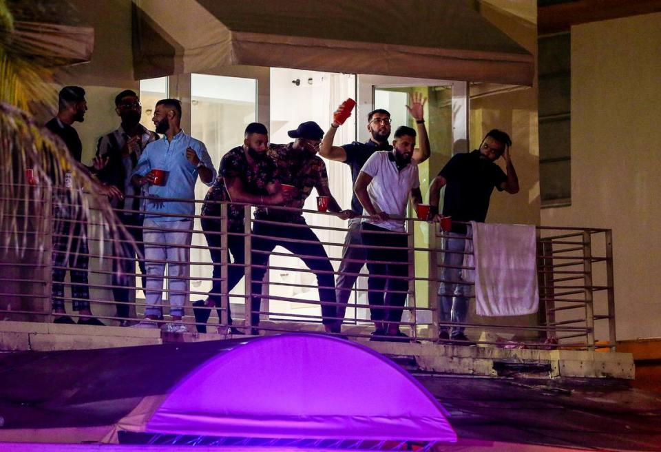 Harp Galsicq​ (third from right) and his friends from Toronto hang out in the balcony of the apartment they rented for his bachelor party in Ocean Drive on Saturday night, March 26, 2022, hours before a midnight curfew, imposed by the City of Miami Beach for the South Beach area, due to two shootings the weekend before, that caused city officials to announce a “state of emergency”.