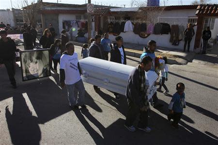 Family members and friends walk with a coffin holding the remains of Idaly Jauche Laguna in Ciudad Juarez December 27, 2013. REUTERS/Jose Luis Gonzalez