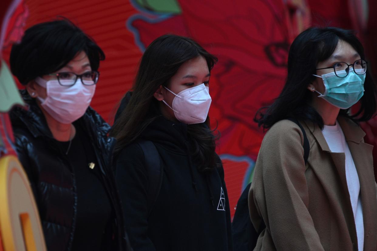 Pedestrians wear face masks in Hong Kong on February 5, 2020, as a preventative measure following a virus outbreak which began in the Chinese city of Wuhan. - More Chinese cities hunkered down by fencing off streets and telling millions of people to stay home as the death toll from the new coronavirus soared to nearly 500 on February 5. Hong Kong now has 18 confirmed infections, the majority people who were infected in mainland China. (Photo by Anthony WALLACE / AFP) (Photo by ANTHONY WALLACE/AFP via Getty Images)
