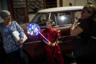 A young dancer from the Cuban Wushu Association returns home with his mother after perform during the ceremony to welcome the Chinese New Year in Havana, Cuba, Friday, Jan. 24, 2020. Cuba's small Chinese community celebrated the Lunar New year Friday night, ushering in the "Year of the Rat" with a colorful parade, brightly lit lanterns and a dragon wending its way through the narrow streets of Chinatown. (AP Photo/Ramon Espinosa)