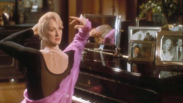 A woman twists her neck at a piano in Death Becomes Her.