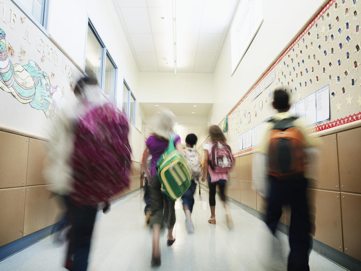 Young students walking down hallway of elementary school.