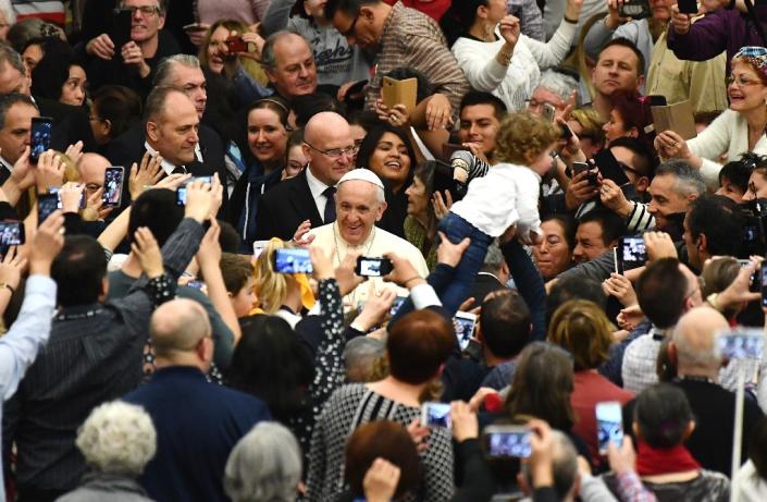 Pope Francis' penchant for having 'selfies' taken with fans has given him an easy, popular touch (AFP Photo/VINCENZO PINTO)