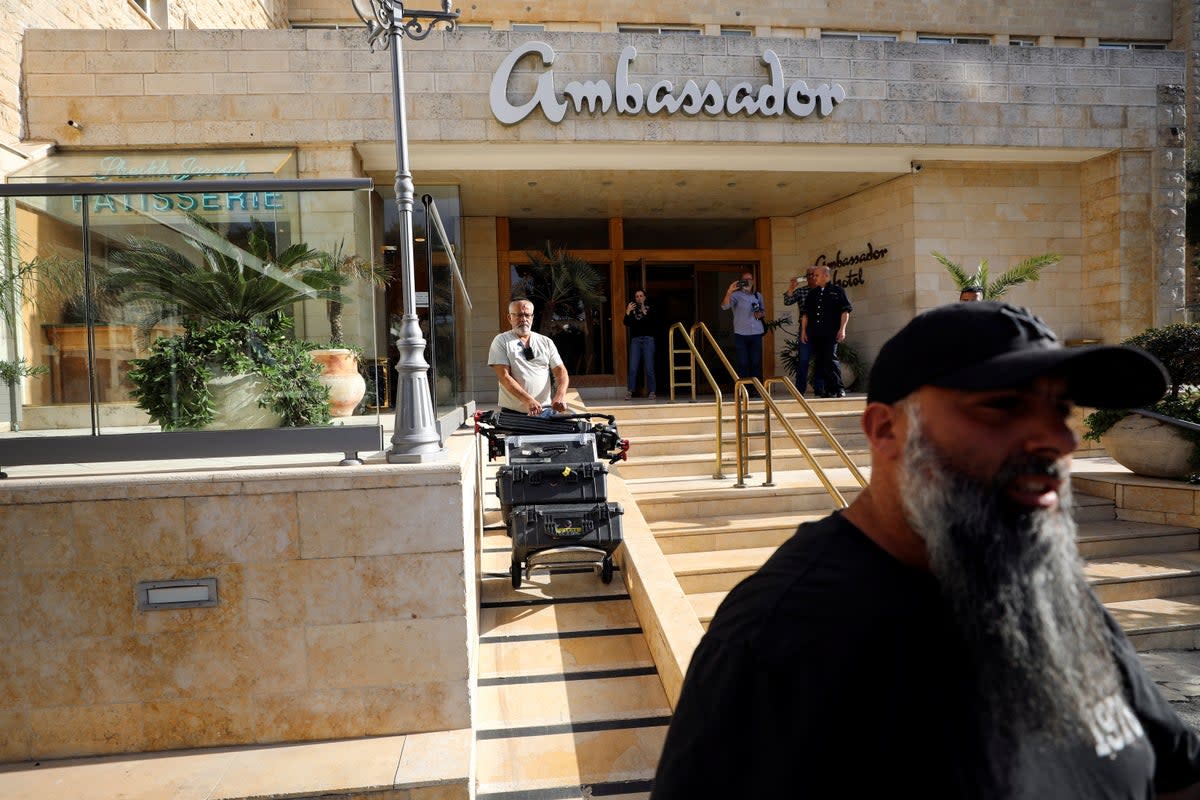 A man manoeuvres media equipment following an Israeli police raid on an Al Jazeera de facto office at the Ambassador Hotel in Jerusalem on Sunday (REUTERS)