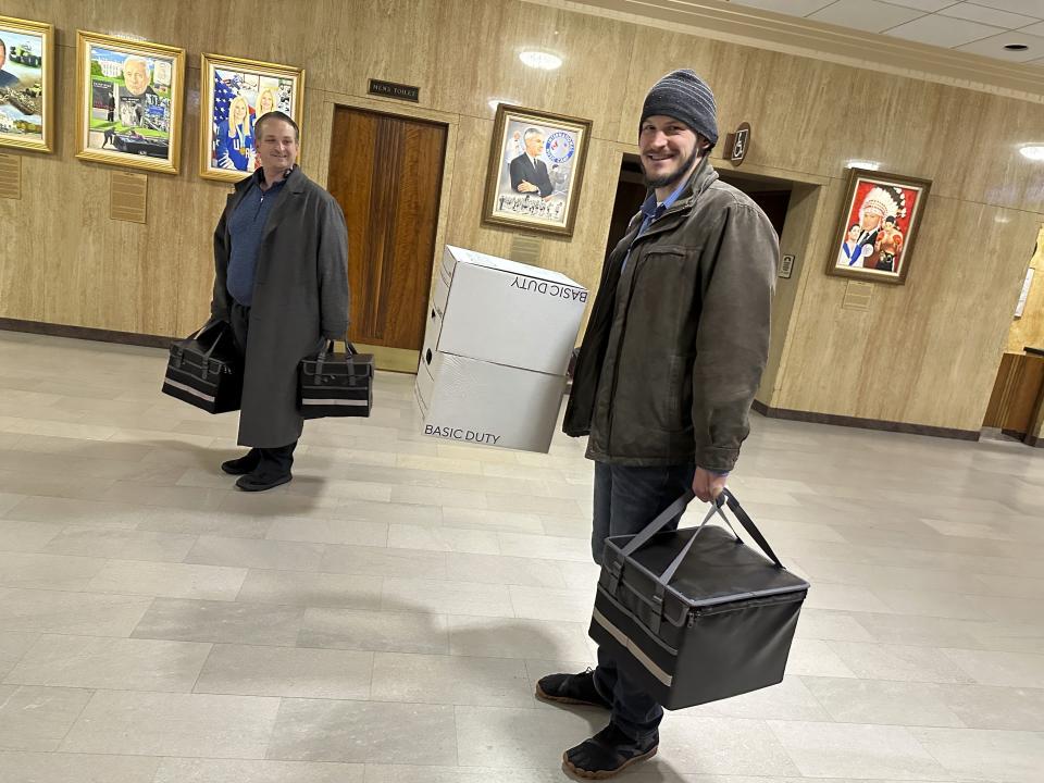 Retire Congress North Dakota Chairman Jared Hendrix, right, carries boxes of petitions with U.S. Term Limits National Field Director Scott Tillman, left, into the state Capitol in Bismarck, N.D., Friday, Feb. 9, 2024. They submitted the petitions to state election officials to qualify an initiative for the June ballot, to set an age limit for North Dakota congressional candidates. (AP Photo/Jack Dura)