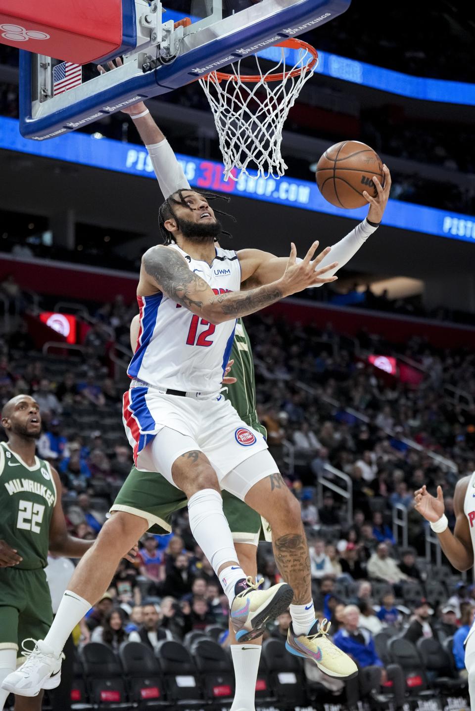 Pistons forward Isaiah Livers goes up for a shot against Bucks center Brook Lopez in the first half on Monday, March 27, 2023, at Little Caesars Arena.
