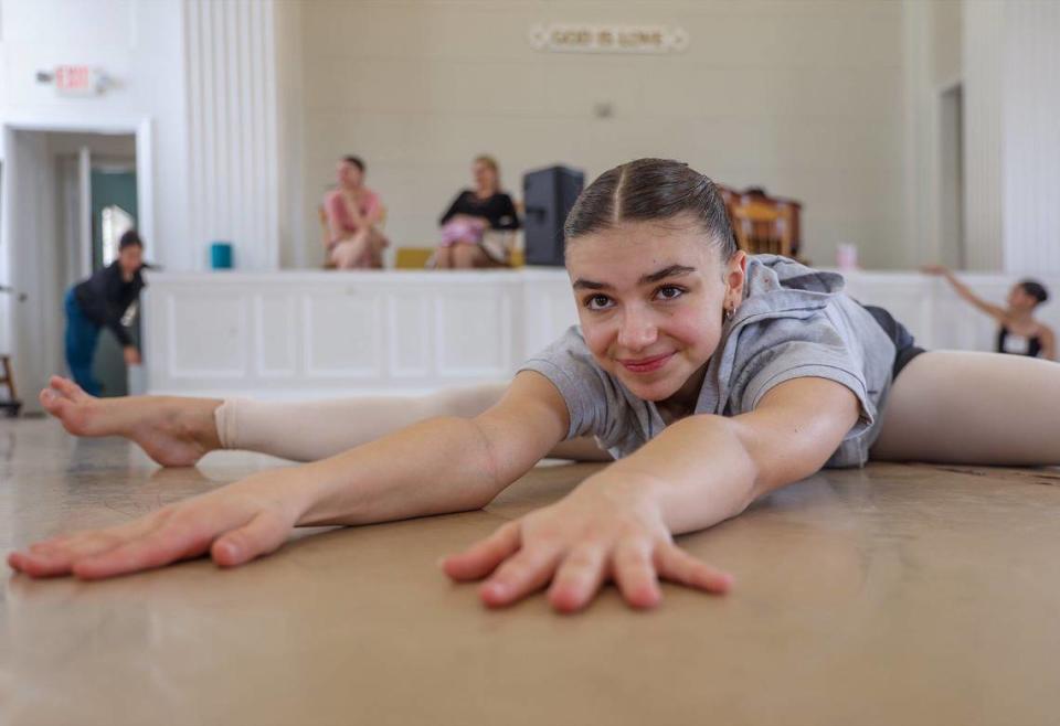 Abril Valentina Marinelli, una bailarina argentina de 15 años, estirándose en el suelo antes de ensayar en First Church of Christ, Scientist, en Coral Gables, una de las iglesias reconvertidas en Sactuary of the Arts, el lunes 8 de julio de 2024, en Coral Gables, la Florida.