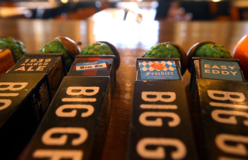 Tap handles sit on the bar Thursday, Dec. 7, 2023 at Big Grove Brewery's new Cedar Rapids location.